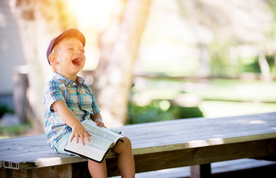 A young child smiling outdoors on a sunny morning.