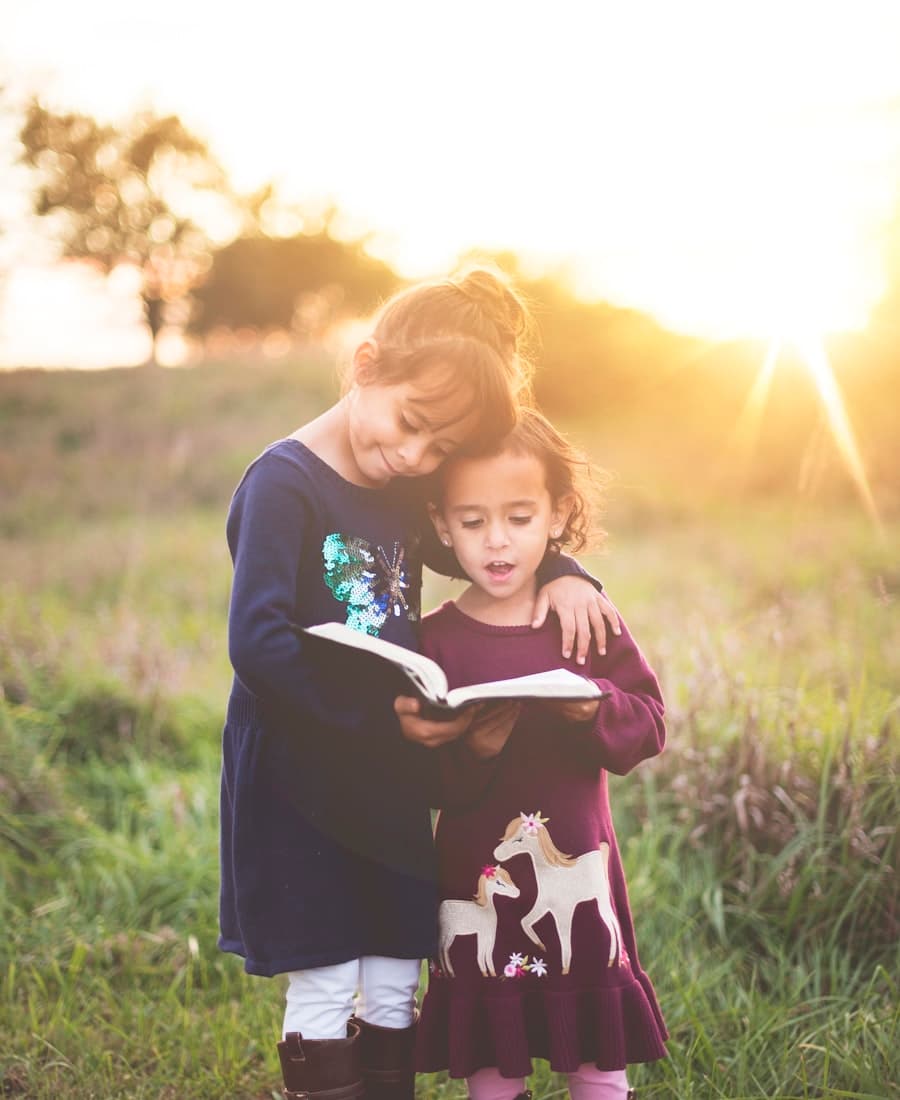 A parent reading a book together with a young child.